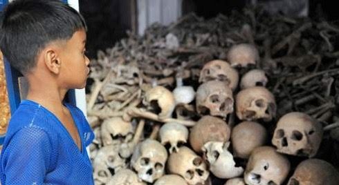 Enfant devant les dépouilles de personnes tués par les Khmers Rouges 